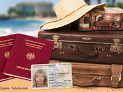 Stapel Koffer, im Vordergrund Reisepass und Personalausweis