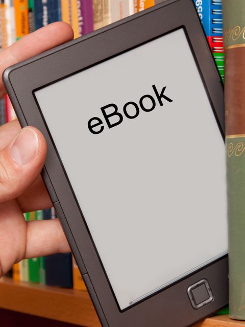 eBook vs Buch, e-Reader aus einem Bücherregal ziehen