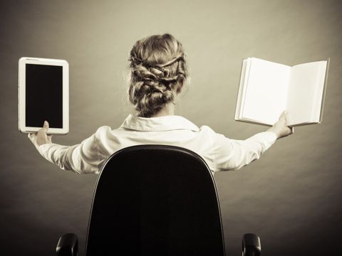 Frau hält ein E-Book-Reader und ein Buch hoch