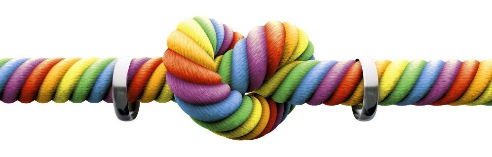 Strick mit Herzknoten in Regenbogenfarben und zwei Ringen