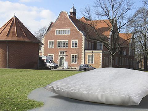 Bildvergrößerung: Das Denkzeichen zeigt ein riesiges Kissen im Park vor der ehemalige "Städtische Heil- und Pflegeanstalt Buch“
