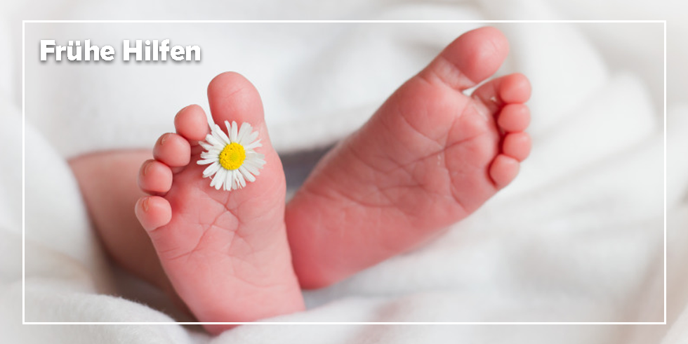 Baby Füße mit einer Blüte zwischen den Zehen. 