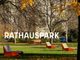 orangene Bänke im Rathauspark mit herbstlichen Blättern im Vordergrund