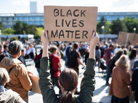 Demonstrantin mit Schild "Black Lives Matter"