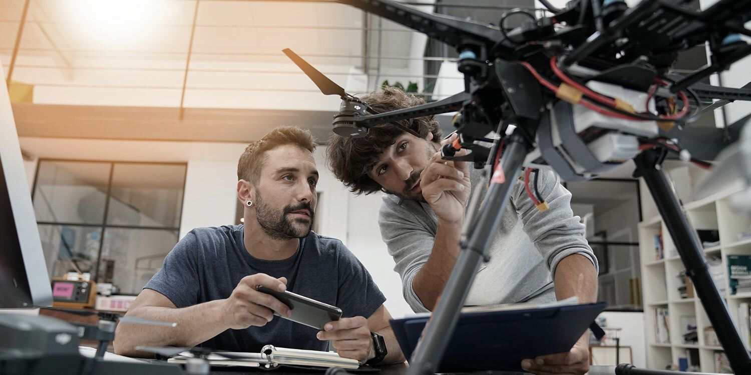 Zwei junge Männer bauen an einer Drohne