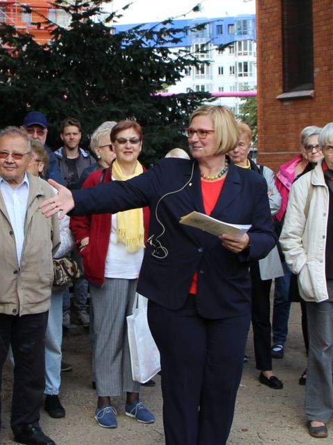 Bildvergrößerung: Frau mit Zettel in der Hand vor Menschenmenge