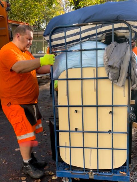 Bildvergrößerung: Ein BSR-Mitarbeiter transportiert einen Container-Wagen mit Sperrmüll