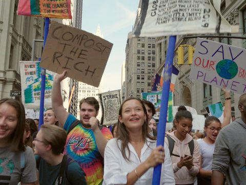Junge Menschen auf einer Demonstration mit Schildern und Plakaten