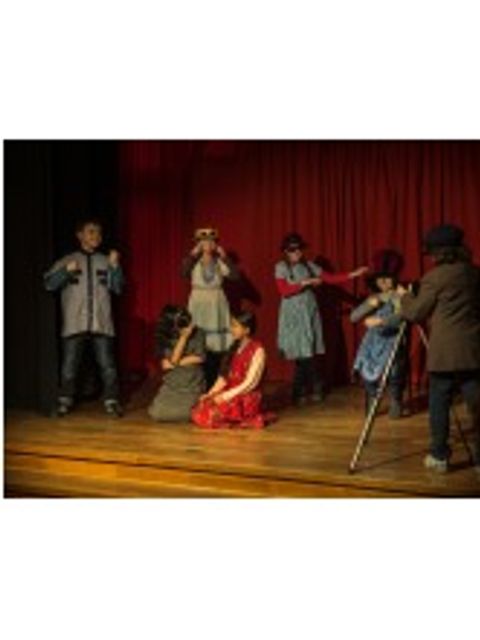 Kinder führen ein Theaterstück auf einer Bühne auf