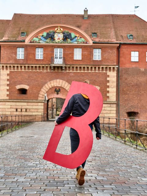 Bildvergrößerung: Person trägt den Buchstaben "B" in Richtung Zitadelle