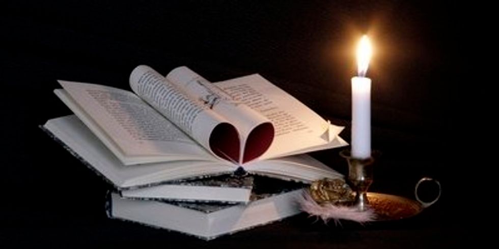 Aufgeschlagenes Buch mit Kerze