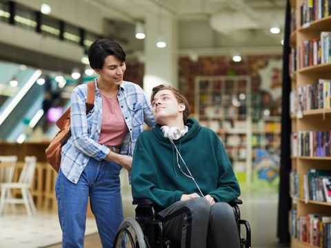 Frau kümmert sich um Mann im Rollstuhl