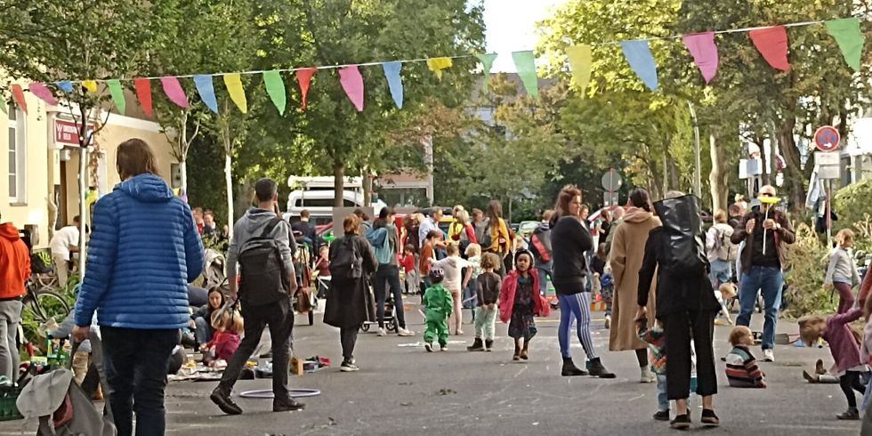 Menschen stehen während des autofreien Tages 2022 auf der Straße und spielen