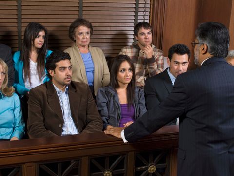 Schöffen blicken auf Anwalt bei Gericht
