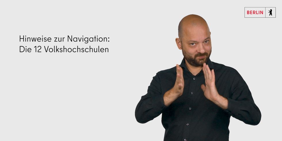 ein Gebärdendolmetschern erklärt in Deutscher Gebärdensprache die Navigation des Webauftrittes der 12 Berliner vhs 