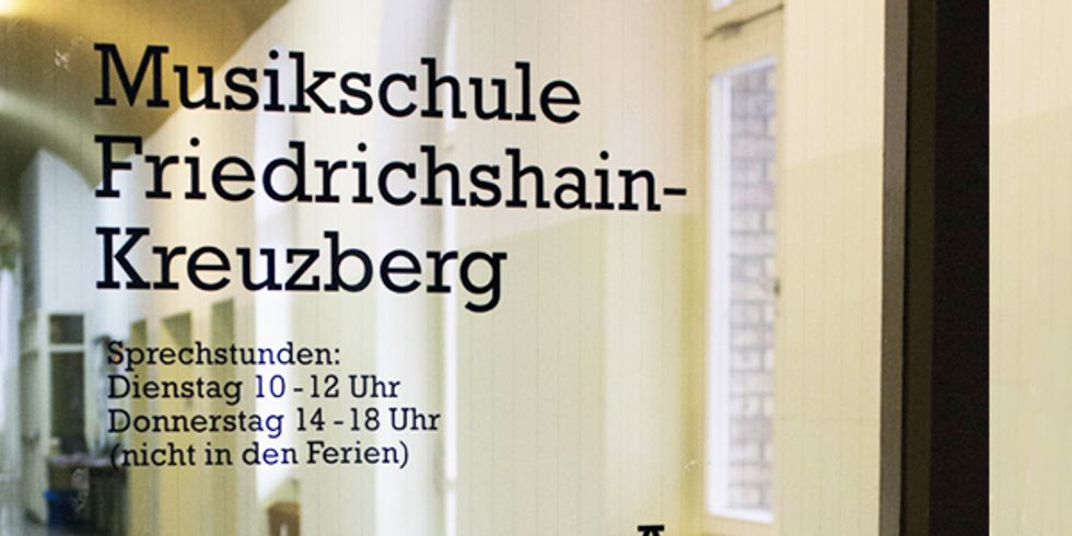 Glastür mit Schriftzug "Musikschule Friedrichshain-Kreuzberg" und Sprechstunden