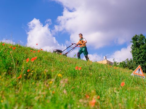 Gärtnerin mäht den Rasen 