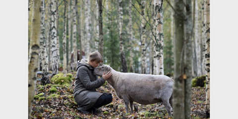 Frau mit Schaf im Wald
