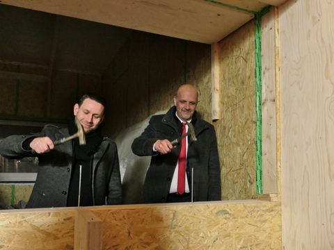 Christoph Keller und Stephan Machulik schlagen symbolisch die letzten Zimmermannsnägel ein