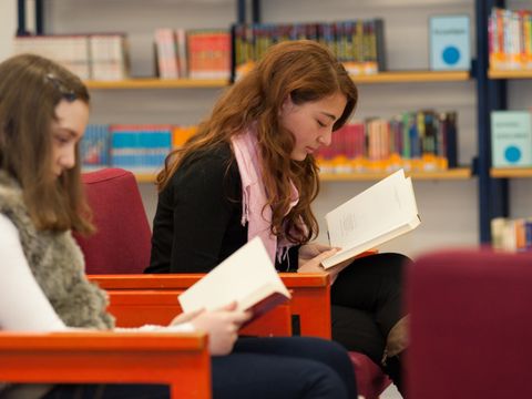 Schülerinnen lesen in der Schulbibliothek