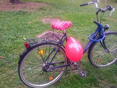 Fahrrad von vorne mit einem roten Luftballon