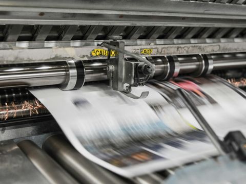 Druckerpresse, aus der Zeitungen kommen 