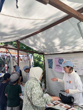 An einem Stand auf einem Kiezfest ist das Team des Raum für Beteiligung Spandau im Gespräch mit Besuchern und Besucherinnen