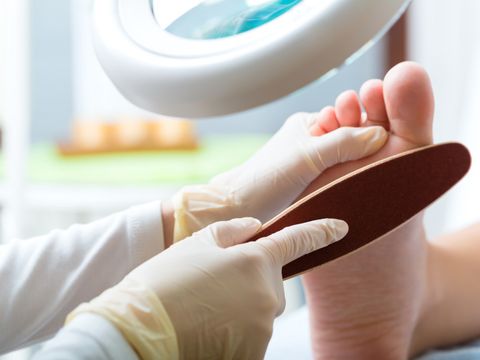 Ein Podologe behandelt den Fuß einer Patientin