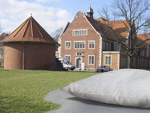 Das Denkzeichen zeigt ein riesiges Kissen im Park vor der ehemalige "Städtische Heil- und Pflegeanstalt Buch“