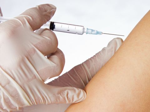 Mediziner verabreicht Spritze an einem Arm