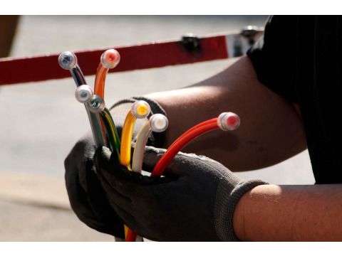 Techniker mit bunten Glasfaserkabeln für schnelles Breitband-Internet