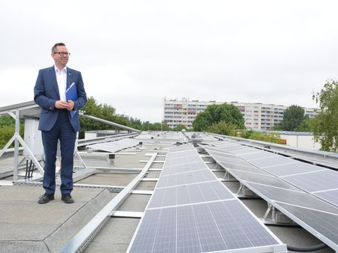 Bildvergrößerung: Bezirksbürgermeister Igel auf dem Dach des Emmy-Noether-Gymnasiums neben der Solaranlage