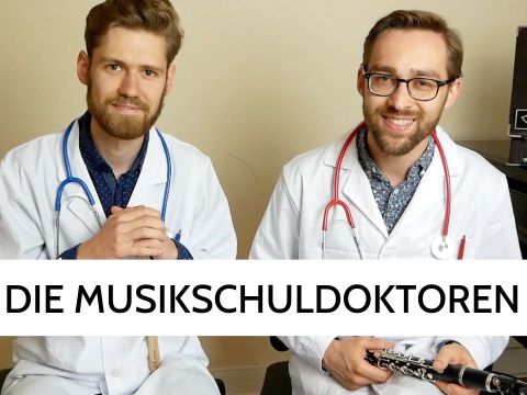 zwei Männer in weißen Kitteln mit Stetoskop und Klarinette 