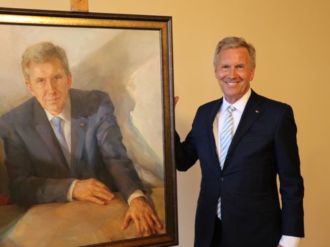 Der frühere Bundespräsident Christian Wulff mit seinem Porträt im Balkonsaal des Rathauses Tiergarten