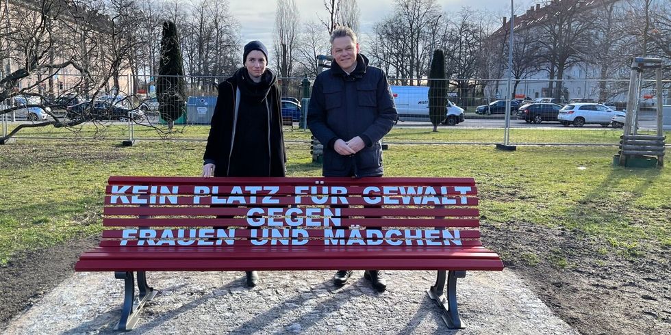 Bezirksstadträtin Saskia Ellenbeck und Bezirksbürgermeister Jörn Oltmann vor der roten Bank mit der Aufschrift "Kein Platz für Gewalt gegen Frauen und Mädchen"