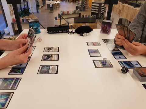 Zwei Spieler am Tisch spielen Magic: The Gathering