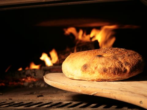 Ein Brot kommt gebacken aus dem Ofen
