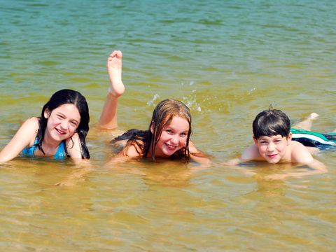 Drei Kinder baden in einem See