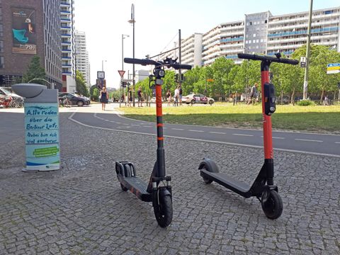 Elektro-Tretroller in Berlin - Zwei E-Roller neben einem Wasserspender an der Leipziger Straße