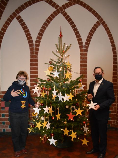 Bildvergrößerung: Bezirksbürgermeister Igel schmückt mit dem Verein "Schenk doch mal ein Lächeln" den Wunschbaum im Foyer des Rathauses Köpenick