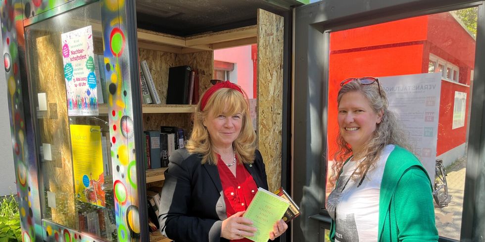 Bezirksstadträtin Juliane Witt überreicht Swantje Ritter zwei Bücher für die neue Büchertauschzelle