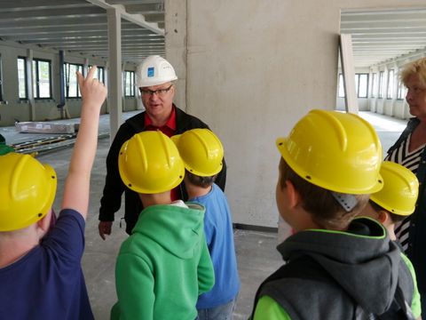 Kinder besichtigen die Baustelle für den Modularen Ergänzungsbau der Grundschule am Bürgerpark 