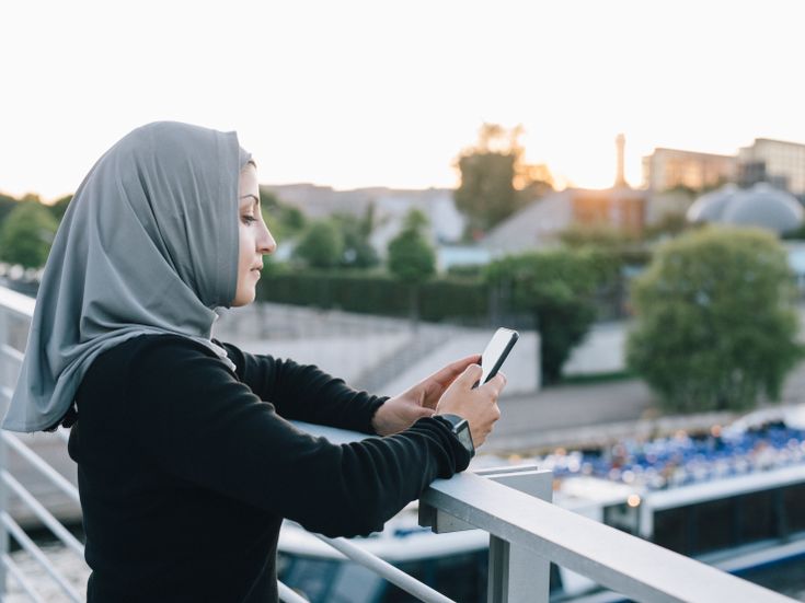 Frau mit Hijab recherchiert am Smartphone