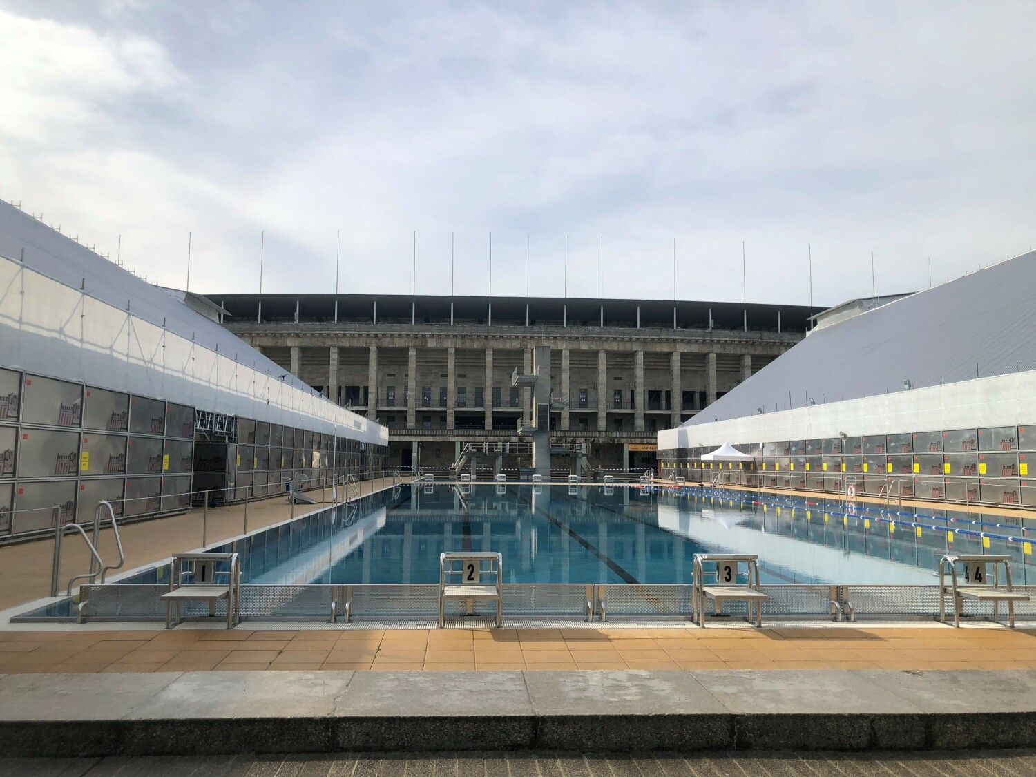 Das Sommerbad Olympiastadion mit Wetterschutzdächern überdeckten Tribünen.
