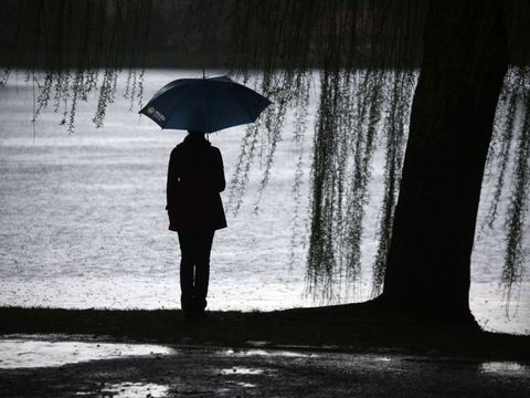 Frau am See im regen