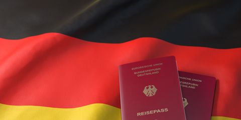 Zwei deutsche Reisepässe liegen auf der deutschen Flagge mit den Farben schwarz-rot-gold