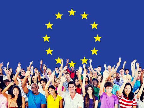 diverse Menschen heben die Hand vor EU-Flagge