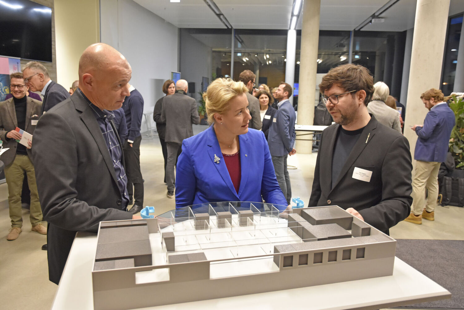 Franziska Giffey am Modell mit zwei weiteren Herren