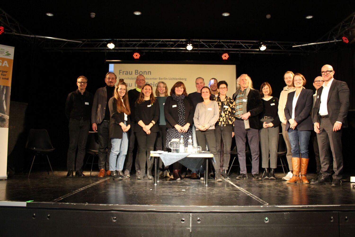 Ein Gruppe von freundliche blickenden Menschen steht zusammen für ein Gruppenfoto.