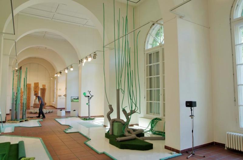 Blick in die Galerie it einer Installation aus Kacheln, Abflussrohren und Gartenschläuchen